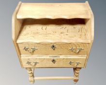 A continental blond oak telephone stand fitted with two drawers.
