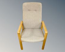 A Scandinavian oak framed armchair in oatmeal coloured fabric