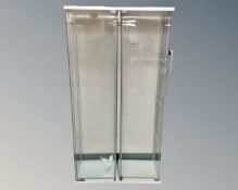 A pair of glass display cabinets with glass shelves,