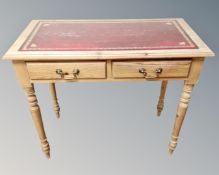 A pine two drawer side table with tooled leather inset panel.