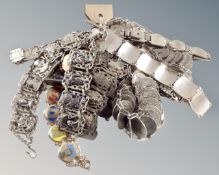 A collection of sixteen white metal coin and place bracelets including two with enamelled place