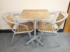 A teak and aluminium patio table and pair of chairs