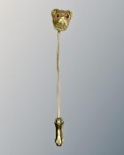 A 14ct yellow gold stick pin modelled as a pug's head set with ruby eyes, length 60 mm, 2.4g.