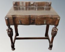 An early 20th century oak serpentine front single drawer hall table.