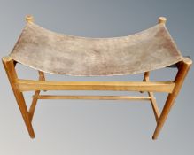 A Scandinavian stool with leather sling seat,