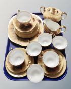 Approximately 24 pieces of Aynsley tea china decorated with fruit on gold ground.