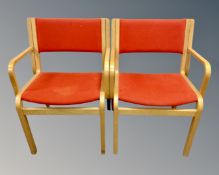 A pair of Scandinavian oak veneered office armchairs in red upholstery,