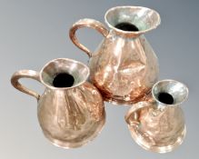 A graduated set of three Victorian copper flagons.