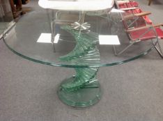 A contemporary glass dining table on spiral support,