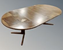 A stained oak extending dining table with two leaves,