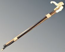 A bundle of three walking sticks with faux ivory handles.