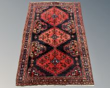 A Kurdish rug on red and black ground, 192cm by 133cm.