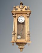 A continental oak eight day wall clock with enamelled dial.