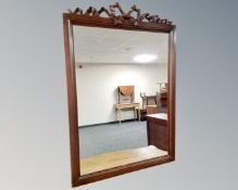 A reproduction mirror with carved ribbon pediment.
