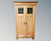 A continental carved oak double door bookcase with leaded glass panels.