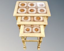 A nest of three blond oak tables.