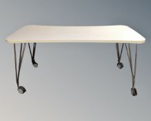 A shaped rectangular table on castors,