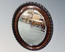 An Edwardian mahogany oval framed mirror.