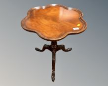 A reproduction tripod table on carved base.