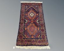 An Afghan/Caucasian long rug on blue ground, 187cm by 84cm.