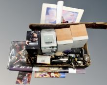 A box containing micro hifi, cameras, movie posters,