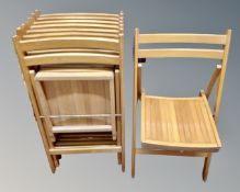 Eight folding chairs in a pine finish
