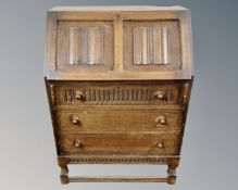 An oak linenfold bureau.