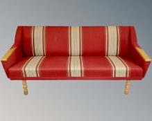 A three piece Danish 20th century lounge suite in red striped fabric with oak arms and legs