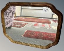 A shaped gilt framed mirror,