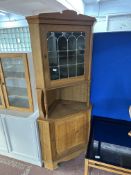 A blonde oak leaded glass corner display cabinet with panel door