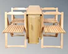 A drop leaf storage kitchen table containing four folding stowaway chairs.
