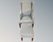 A 20th century wingback armchair and footstool in blue fabric