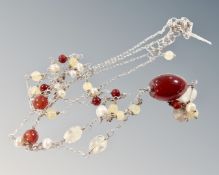 A silver double chain necklace set with beads and pearls