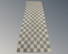 A flat weave runner on green ground,