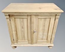 An early 20th century pine double door cabinet on bun feet.