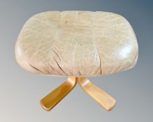 A footstool upholstered in tan leather