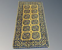 An Afghan design woolen rug on yellow ground,