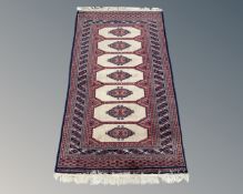 An Afghan rug on blue and beige ground,