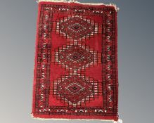 A small Afghan hearth rug 66 cm x 46 cm