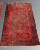 An Afghan Bokhara rug on red ground,