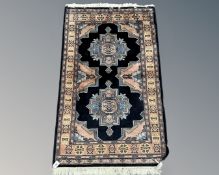 A Caucasian design rug on black ground,