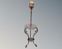 An antique ornate cast iron rise and fall oil lamp table