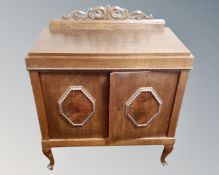 A 20th century oak double door cabinet on cabriole legs