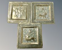 A set of three Indian brass panels a lion,