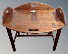 A butler's tray on stand in mahogany finish