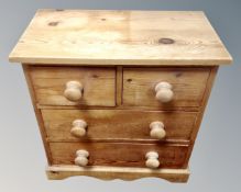 A pine four drawer bedside chest
