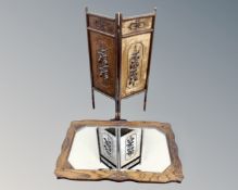 An Edwardian oak framed bevelled mirror together with a two-way embossed fire screen