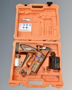 A Paslode impulse nail gun with battery and charger in case