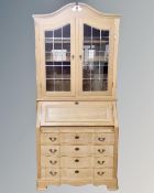 A Scandinavian blonde oak bureau bookcase