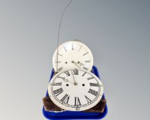 Two Continental longcase clock movements with circular painted dials together with a pendulum